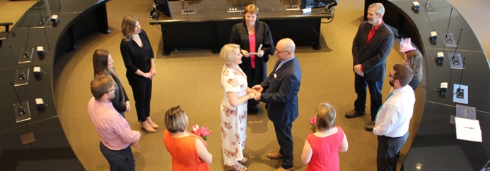 Wedding guests standing in the centre of Council Chambers around the bridal couple.